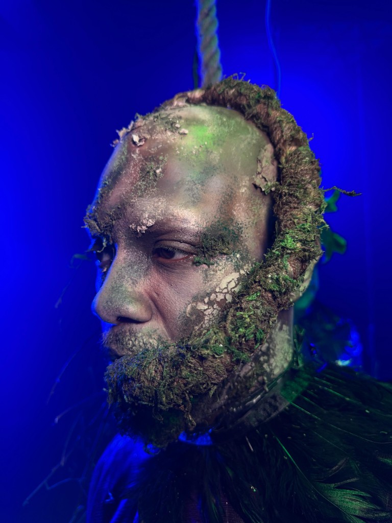 Moss and bark prosthetic under blue light